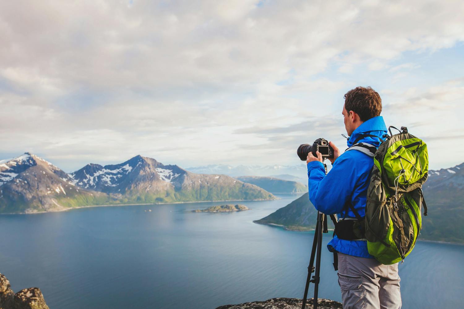 Landskapsfotograf framför bergslandskap med full packning